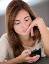 Bored woman texting on her mobile phone